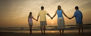 Family Holding Hands On Beach