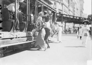 A mother helps a kid off the trolly car in New York City in July, 1913
